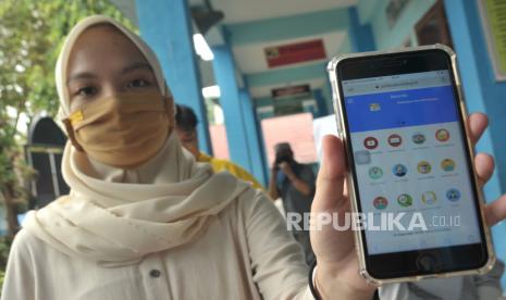 Orang tua calon siswa menunjukkan web pendaftaran penerimaan peserta didik baru (PPDB) sekolah dasar.