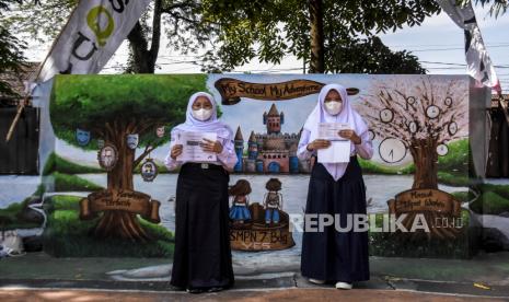 Sejumlah pelajar menunjukkan sertifikat vaksinasi Covid-19 usai disuntik vaksin Covid-19 di SMPN 7 Bandung, Jalan Ambon, Kota Bandung, Selasa (21/9). Pemerintah Kota Bandung menyatakan program vaksinasi Covid-19 dosis pertama bagi pelajar di Kota Bandung telah mencapai 76 persen dan dosis kedua mencapai 50 persen. Foto: Republika/Abdan Syakura