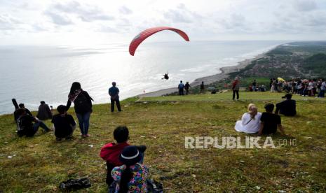 Wisatawan duduk di landasan paralayang Watu Gupit menunggu senja, Purwosari, Gunung Kidul, Yogyakarta. Pemkab akan menjadikan Gunungkidul sebagai destinasi wisata berkelas internasional.