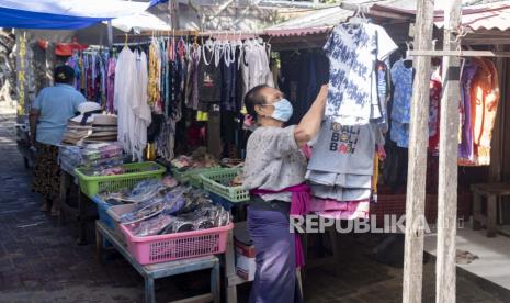 Seorang wanita menunggu pelanggan di luar tokonya di Sanur, Bali, Indonesia, 09 Juni 2021. Pemerintah Indonesia telah merencanakan untuk membuka kembali pulau resor Bali untuk turis asing pada akhir Juli 2021.