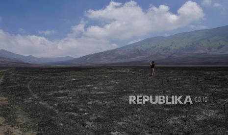 Seorang wisatawan mengabadikan gambar kondisi padang sabana di Bukit Teletubbies, Probolinggo, Jawa timur, Selasa (19/9/2023). Balai Besar Taman Nasional Bromo Tengger Semeru (BBTNBTS) kembali membuka kawasan wisata Gunung Bromo yang sempat ditutup total selama 9 hari akibat kebakaran yang disebabkan suar yang dinyalakan pengunjung.  