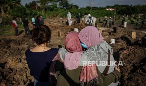 Kerabat menangis saat menyaksikan pemakaman keluarganya yang meninggal dunia akibat COVID-19