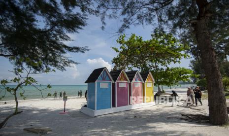 Wisatawan berjalan di tepi Pantai Teluk Lagoi, Bintan, Kepulauan Riau, Ahad (1/11/2020). Pemerintah provinsi setempat menargetkan Pantai Teluk Lagoi dan sejumlah destinasi wisata lain di wilayahnya kembali bergeliat setelah dibukanya kembali jalur perbatasan Batam-Singapura.  