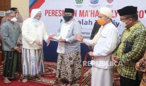 Menag Sosialisasi Aturan Sholat Idul Adha di Lirboyo Kediri. Menteri Agama Yaqut Cholil Qoumas (tengah) menerima cenderamata berupa buku dari pengasuh pondok pesantren Lirboyo KH Anwar Manshur (kedua kiri) saat peresmian perguruan tinggi Islam berbasis kitab kuning Ma