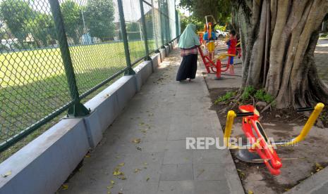 Warga berolahraga sambil mengasuh anak di fasilitas olahraga Lapangan Karang, Kotagede, Yogyakarta. Pembagian tugas menjadi salah satu cara hindari stres saat asuh anak