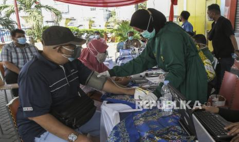 Petugas kesehatan mengukur tekanan darah seorang pedagang (kiri) yang akan mengikuti vaksinasi COVID-19 di Cikarang, Kabupaten Bekasi, Jawa Barat, Rabu (7/7/2021). Sebanyak 300 pedagang di wilayah Kabupaten Bekasi mengikuti vaksinasi guna mencegah penyebaran wabah COVID-19. 