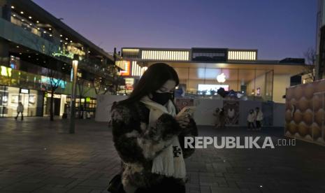 Seorang wanita bertopeng berjalan di sepanjang mal di Beijing, Rabu, 28 Desember 2022. China mengatakan akan melanjutkan penerbitan paspor untuk pariwisata sebagai langkah besar menjauh dari kontrol anti-virus yang mengisolasi negara itu selama hampir tiga tahun. potensi banjir warga Tionghoa yang pergi ke luar negeri untuk liburan Tahun Baru Imlek bulan depan.