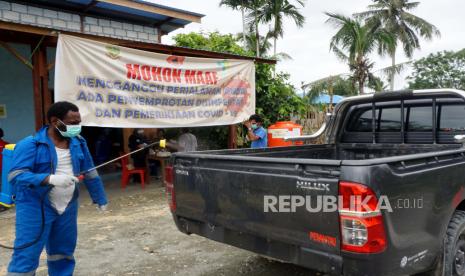 Petugas menyemprot disinfektan pada kendaraan roda empat di pos Covid-19, Arsopura, Distrik Skanto, Kabupaten Keerom, Papua, Senin (13/4). (ilustrasi)