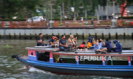 Sejumlah warga menaiki kelotok (perahu bermesin) tanpa jaga jarak saat susur Sungai Martapura di kawasan wisata Menara Pandang Siring Sungai Martapura Banjarmasin, Kalimantan Selatan, Ahad (21/6/2020). Meski Pemerintah Kota Banjarmasin belum membuka wisata Menara Pandang namun warga mulai ramai memadati kawasan salah satu landmark di Kalimantan Selatan itu