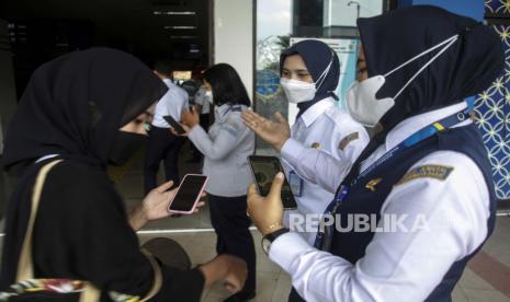 Petugas memeriksa sertifikat vaksin COVID-19 dan membagikan masker bagi penumpang yang tiba di Terminal Tirtonadi Solo, Jawa Tengah, Rabu (13/4/2022). Kegiatan tersebut sebagai penegakan protokol kesehatan (prokes) bagi penumpang terminal setempat menjelang musim mudik 2022. 