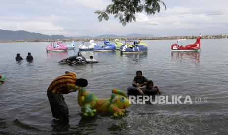 Lampung Tutup Tempat Wisata pada Libur Idul Fitri. Anak-anak berenang menggunakan pelampung mainan di tengah pandemi COVID-19 di pantai Ule Lhuee, Aceh, Jumat (30/10/2020). Pariwisata menjadi sektor yang paling menderita kerugian akibat pembatasan perjalanan oleh semua negara di dunia akibat pandemi virus corona. Indonesia telah kehilangan sekitar Rp 85 triliun (5,87 miliar dolar AS) pendapatan pariwisata sepanjang tahun ini.