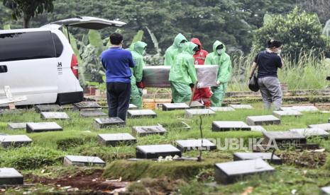 Petugas pemakaman membawa peti jenazah pasien Covid-19 