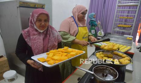 Pekerja memproduksi kue donat berbahan dasar buah labu dan singkong di rumah UMKM Getlatela, Kampung Keuramat, Banda Aceh, Aceh, Jumat (12/11/2021). Pelaku UMKM binaan BUMN itu menyatakan produksi kue donat berbahan dasar buah labu dan singkong tersebut sejak setahun terakhir di tengah pandemi COVID-19 mulai bangkit setelah pemasarannya beralih menggunakan media daring. 