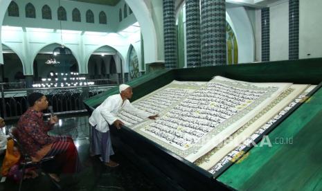 Bupati Banyuwangi Minta Masukan Ulama Terkait New Normal. Foto: Umat Islam bertadarus membaca Al Quran raksasa di Masjid Baiturrahman, Banyuwangi, Jawa Timur, Senin (27/4/2020). Al Quran raksasa tulisan tangan H Abdul Karim berukuran halaman 142 x 210 centimeter tersebut mulai ditulis pada 1 Februari 2010 dan selesai pada 26 Agustus 2010 untuk dibaca setiap bulan Ramadhan di Masjid Baiturrahman Banyuwangi