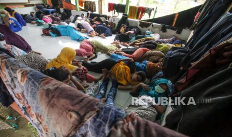 Pengungsi etnis Rohingya beristirahat di balai Desa Alue Buya Pasie, Jangka, Kabupaten Bireun, Aceh, Senin (7/3/2022).  Sebanyak 114 orang etnis Rohingya yang terdiri dari 58 laki-laki, 21 perempuan dan 35 anak-anak yang terdampar di perairan Jangka Bireuen pada Minggu (6/7/2022) itu masih menunggu rapat koordinasi antara UHNCR, IOM dengan pemerintah daerah terkait relokasi etnis Rohingya ke tempat penampungan sementara di Aceh.