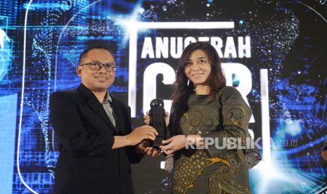 Direktur Republika Media Mandiri, Nur Hasan Murtiaji (kiri) menyerahkan trophy CSR kepadaVP CSR BRI Dinne Shovia Tresna Amalia (kanan) dalam acara Anugerah CSR 2023 Republika di Jakarta, Kamis (26/10/