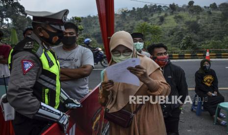 Petugas memberikan hasil pemeriksaan tes cepat (rapid test) Antigen COVID-19 kepada pemudik di Jalur Selatan Pos penyekatan leter U Gentong, Kabupaten Tasikmalaya, Jawa Barat, Minggu (16/5/2021). Pemerintah menggelar random atau acak testing COVID-19 secara gratis bagi pemudik yang melintas di Jalur Selatan, Jawa, menuju Bandung dan Jakarta untuk mengatisipasi lonjakan kasus COVID-19 pasca Lebaran. 