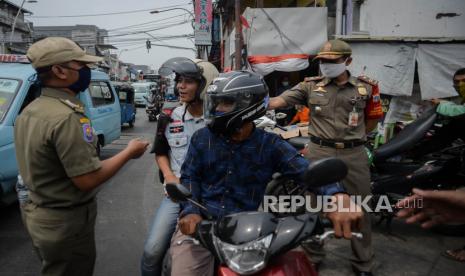 Petugas Satpol PP melakukan razia masker di kawasan Jatinegara, Jakarta, Jumat (11/9).  Pemerintah Provinsi DKI Jakarta akan melakukan pembatasan sosial berskala besar (PSBB) secara total pada tanggal 14 September mendatang, akibat peningkatan kasus harian positif covid-19 di DKI Jakarta. Republika/Thoudy Badai