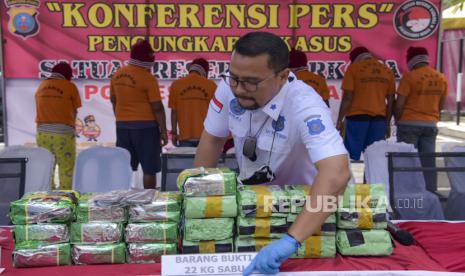 Petugas menyusun barang bukti narkoba jenis sabu saat rilis kasus narkoba di Polrestabes Medan, Sumatera Utara, Rabu (20/10/2021). Polrestabes Medan mengamankan delapan orang tersangka dan menyita sabu-sabu seberat 23 kg, satu senjata api jenis revolver dengan 17 amunisi dan uang tunai sekitar Rp41 juta. 