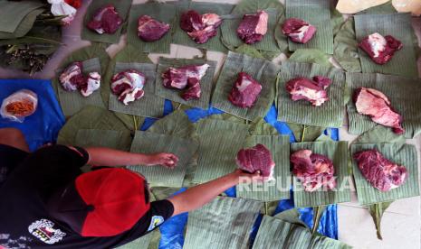 Warga menata daging kurban di atas alas daun pisang dan daun jati 