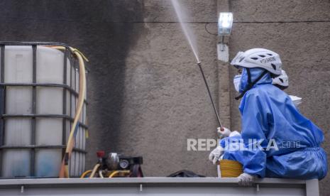 Petugas menyemprotkan cairan disinfektan di kawasan perumahan warga.