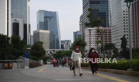 Sejumlah pekerja berjalan usai bekerja dengan latar belakang gedung perkantoran di Jl Jenderal Sudirman, Jakarta, Kamis (16/4). Perusahaan-perusahaan di Amerika Serikat (AS) merampingkan jejak properti fisiknya karena lebih banyak karyawan bekerja dari rumah.