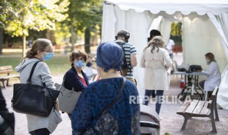 Sejumlah orang mengantri untuk mengikuti uji untuk COVID-19 di pusat pengujian seluler di Strasbourg, Prancis timur, Rabu (23/9). Menteri Kesehatan Prancis Olivier Veran mengumumkan penutupan semua restoran dan bar di wilayah Marseille dan pembatasan di beberapa kota lain untuk membendung penyebaran Covid-19. Saat ini pasien Covid-19 telah menempati lebih dari 10% tempat tidur perawatan intensif Prancis. Foto AP / Jean-Francois Badias