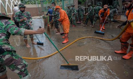 Personel gabungan dari TNI, Polri, petugas Pemadam Kebakaran, PPSU, dan warga sekitar membersihkan endapan lumpur sisa banjir di area Masjid Al-Hidayah, Cipinang Melayu. Jakarta Timur, Senin (22/2). Kegiatan kerja bakti tersebut dilakukan diarea tempat ibadah agar dapat digunakan kembali untuk beribadah. Republika/Thoudy Badai