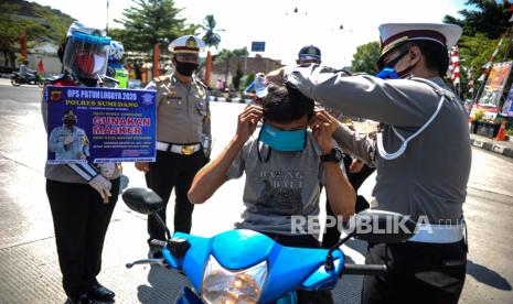 Petugas mengenakan masker kepada seorang pengguna kendaraan saat Operasi Patuh Lodaya (ilustrasi). Selama Operasi Patuh Lodaya 2020 yang digelar oleh jajaran Polres Sukabumi Kota telah menindak sebanyak 3.958 pelanggaran lalu lintas. Di mana mayoritas ditindak dalam bentuk teguran dan sisanya sanksi tilang.