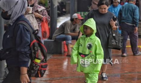 Warga mengenakan jas hujan untuk beraktivitas di Stasiun Tebet, Jakarta, Selasa (30/1/2024). 