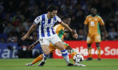 Gelandang Real Sociedad Mikel Merino (kiri) berebut bola melawan pemain Betis Paul Akouokou selama pertandingan sepak bola LaLiga Spanyol antara Real Sociedad dan Real Betis di stadion Reale Arena di San Sebastian, Spanyol utara, 30 Oktober 2022.