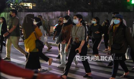 Sejumlah pekerja melintas di pelican cross kawasan Sudirman, Jakarta, Selasa (17/5/2022).  Presiden Joko Widodo melonggarkan kebijakan terkait aturan pemakaian masker dengan  memperbolehkan warga tidak mengenakan masker di luar ruangan apabila tidak dalam kondisi kerumunan menyusul kondisi pandemi COVID-19 di Indonesia saat ini terkendali. 