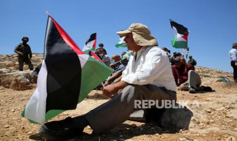 UEA Nyatakan Terus Dukung Palestina. Anggota pasukan keamanan Israel berjaga-jaga saat warga Palestina melakukan sholat Jumat selama protes di desa Tepi Barat Yatta, dekat Hebron, 21 Agustus 2020. Warga Palestina memprotes perjanjian perdamaian untuk membangun hubungan diplomatik antara Israel dan Uni Emirat Arab .