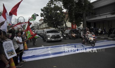 Massa yang tergabung dalam Tepi Barat Perisai Al-Quds melakukan Aksi Solidaritas Palestina, di depan Gedung Merdeka, Jalan Asia Afrika, Kota Bandung, Jawa Barat, Jumat (14/4/2023). Dalam aksi untuk memperingati Hari Al Quds Internasional 2023 tersebut mereka mengecam berbagai tindakan Amerika dan Israel terhadap Palestina. Selain itu, mereka meminta pemerintah Indonesia mengambil langkah konkret dalam memperjuangkan kemerdekaan Palestina.