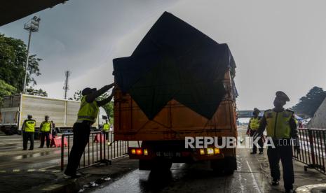 Petugas Kepolisian memeriksa truk yang melintas di check point penyekatan arus mudik Tol Cikupa, Tanggerang, Kamis (6/5). Petugas gabungan memberlakukan penyekatan pemudik jelang perayaan Hari Raya Idul Fitri 1442 H guna mengantisipasi risiko peningkatan kasus penularan COVID-19. Republika/Putra M. Akbar