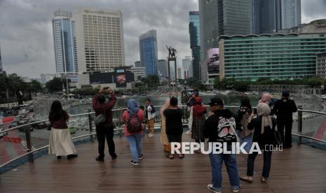 Pengunjung berfoto di anjungan Halte Bundaran Hotel Indonesia, Jakarta, Rabu (25/12/2024). Pada masa libur Natal dan Tahun Baru 2024-2025, sejumlah warga memanfaatkan waktunya untuk berlibur menikmati lanskap perkotaan dan berswafoto di anjungan Halte Bundaran HI. Keberadaan anjungan Halte Bundaran HI tersebut menjadi destinasi wisata alternatif di Jakarta yang memiliki daya tarik tersendiri dengan menyajikan spot foto dengan latar belakang patung Selamat Datang dan lanskap Perkotaan. Selain itu, di halte tersebut juga menyediakan beragam kuliner dan fasilitas lainnya seperti musala dan toilet untuk memberikan kenyamanan bagi para pengunjung. Bagi warga yang hendak berwisata di halte tersebut, cukup menempelkan Kartu Uang Elektronik (KUE) di mesin pintu masuk seperti penumpang bus transjakarta lainnya.