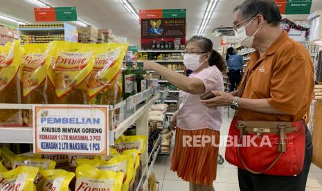  Seorang wanita membeli minyak goreng di supermarket di Denpasar, Bali,  24 Maret 2022. Indonesia, produsen minyak sawit terbesar dunia, dilanda kelangkaan minyak goreng yang menyebabkan kenaikan harga eceran minyak goreng kemasan.