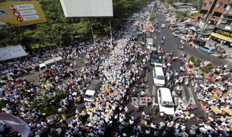 Demonstran berbaris selama protes terhadap kudeta militer Myanmar, di Yangon, Myanmar, 22 Februari 2021. Bisnis ditutup dan ribuan demonstran anti-kudeta turun ke jalan untuk pemogokan umum nasional yang disebut pemberontakan 22222 atau Lima Dua, mengacu pada Tanggal, 22 Februari 2021, meski junta militer memperingatkan adanya kekuatan mematikan.