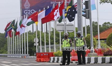 Polisi berjaga saat bendera negara G20 berkibar di jalan menuju tempat KTT G20 di Nusa Dua, Bali, (ilustrasi). 