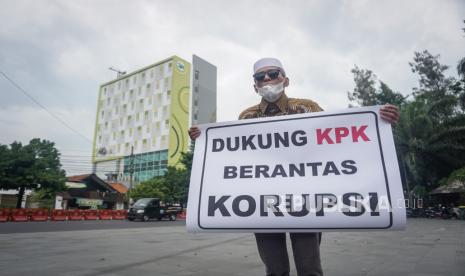 Pegiat sosial Hasan Mulachela melakukan aksi tunggal dengan mambawa poster dukungan kepada Komisi Pemberantasan Korupsi (KPK), di Manahan, Solo, Jawa Tengah, Senin (7/12/2020). Aksi tersebut sebagai bentuk dukungan terhadap KPK yang melakukan Operasi Tangkap Tangan (OTT) terhadap sejumlah pejabat Kementerian termasuk Menteri yang terlibat kasus korupsi. 