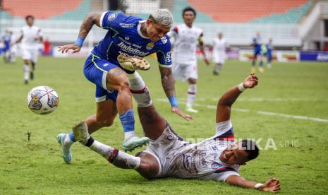 Pesepak bola Arema FC Joko Susilo (kanan) terjatuh saat berebut bola dengan pesepak bola Persib Bandung Ciro Alvez (kiri) dalam pertandingan lanjutan BRI Liga 1 di Stadion Pakansari, Kabupaten Bogor, Jawa Barat, Kamis (23/2/2023). Persib Bandung mengalahkan Arema FC  1-0.  