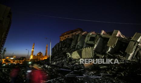 Warga Palestina memeriksa menara Hanadi yang hancur setelah serangan udara Israel di Kota Gaza, 11 Mei 2021. 