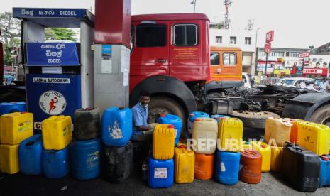 Seorang pria duduk di sebelah kaleng bensin di sebuah pompa bensin di tengah kekurangan bahan bakar di Kolombo, Sri Lanka, 17 Mei 2022. Presiden Sri Lanka, Gotabaya Rajapaksa, melakukan panggilan telepon dengan pemimpin Rusia Vladimir Putin meminta dukungan kredit untuk mengimpor bahan bakar.