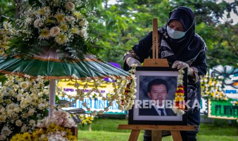 Kerabat mengalungkan bunga pada foto di pusara makam Mohamad Hasan Gatot Soebroto (Bob Hasan) saat prosesi pemakaman di Taman Makam Pahlawan Gatot Soebroto, Ungaran Timur, Kabupaten Semarang, Jawa Tengah, Rabu (1/4/2020). Pengusaha yang juga Ketua Persatuan Atletik Seluruh Indonesia (PASI) serta mantan Menteri Perindustrian dan Perdagangan pada era Orde Baru itu wafat pada usia 89 tahun karena kanker paru-paru