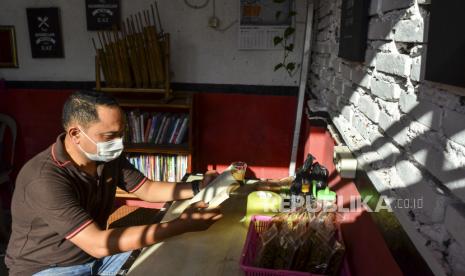 Warga membaca buku di sebuah warung Program Keluarga Harapan (PKH) Shop, Kabupaten Ciamis, Jawa Barat, Selasa (24/8/2021). Program Keluarga Harapan Ciamis mendirikan 12 PKH Shop untuk memfasilitasi pemberdayaan keluarga penerima manfaat yang masih aktif untuk menunjang sarana tempat kegiatan usaha sekaligus belajar berwirausaha dengan menjual berbagai produk makanan hasil olah KPM serta menyediakan sarana pojok baca. 