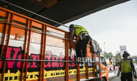 Petugas Kepolisian memeriksa truk yang melintas di check point penyekatan arus mudik Gerbang Tol Cikupa, Tangerang, Banten, Kamis (6/5/2021). Petugas gabungan memberlakukan penyekatan pemudik jelang perayaan Hari Raya Idul Fitri 1442 H guna mengantisipasi risiko peningkatan kasus penularan COVID-19.