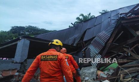  Gambar selebaran yang disediakan oleh Badan Pencarian dan Penyelamatan Nasional Indonesia (BASARNAS) menunjukkan penyelamat mencari korban di bawah reruntuhan bangunan yang runtuh setelah gempa berkekuatan 6,2 di Mamuju, Sulawesi Barat, Indonesia, 15 Januari 2021. Setidaknya tiga orang tewas dan puluhan luka-luka.