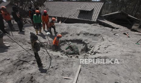 Relawan melakukan proses evakuasi lanjutan korban yang diduga masih tertimbun longsoran material awan panas di Kampung Renteng, Desa Sumberwuluh, Kecamatan Candipuro, Kabupaten Lumajang, Jawa Timur, Rabu (8/12).