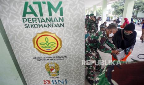 Warga dibantu personel TNI mengambil beras gratis di ATM pertanian Si Komandan di Kodim 0621 Kabupaten Bogor, Cibinong, Bogor, Jawa Barat, Ahad (26/4/2020).  Kementerian Pertanian menempatkan ATM beras gratis di sejumlah Kodim di wilayah Jabodetabek dan membagikan 1,5 ton beras per harinya  sebagai upaya membantu masyarakat miskin yang terkena dampak COVID-19