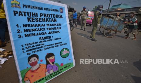 Petugas Satpol PP menegur warga yang tidak memakai masker saat melintas di tempat umum.